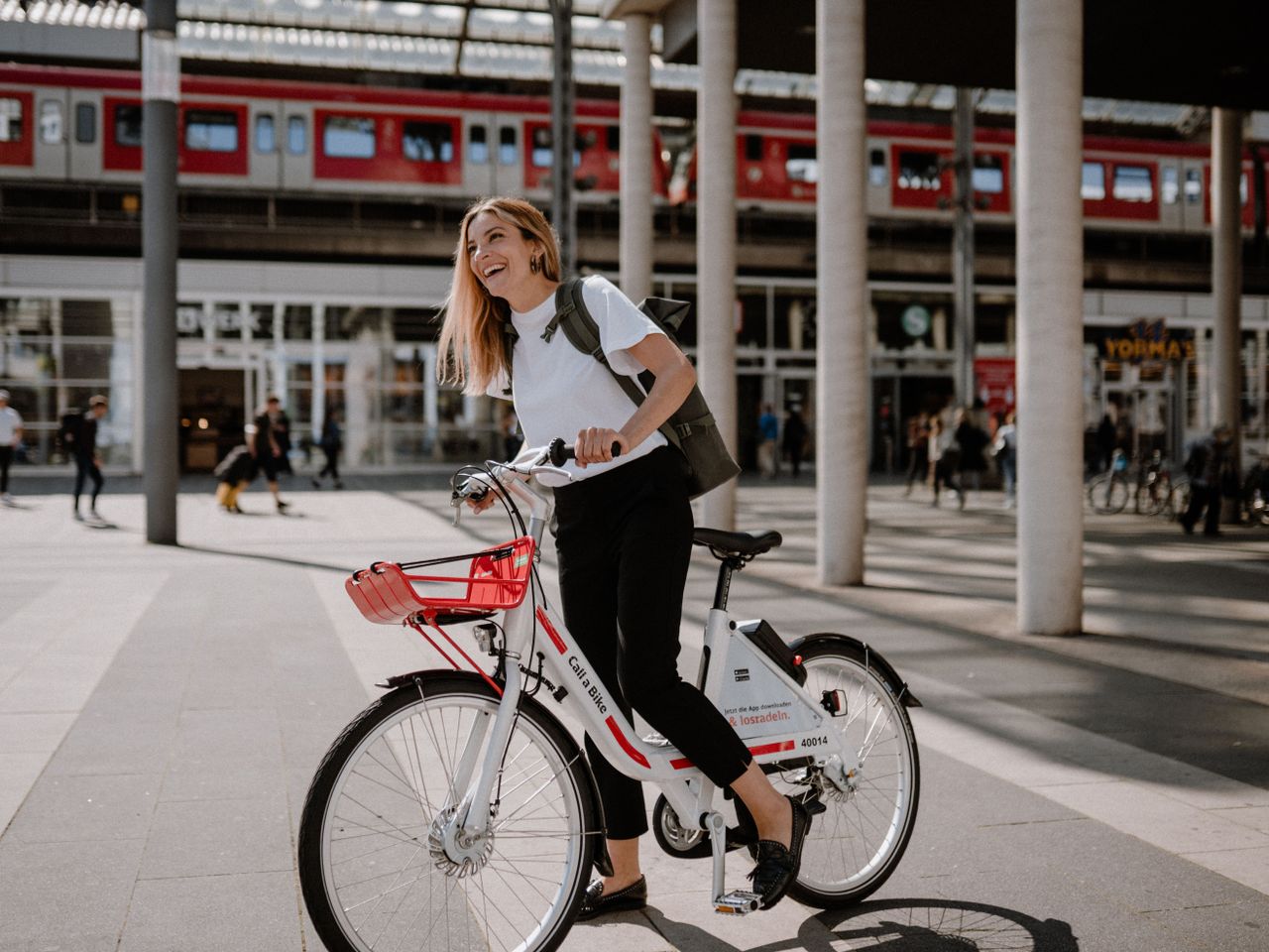 Frau mit Call a Bike vor Bahnhof
